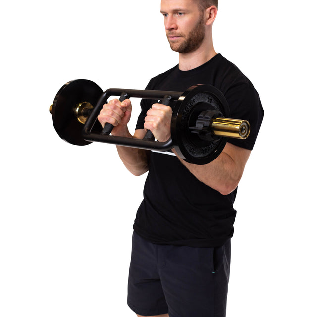 A man in a black t-shirt and shorts holds a Bells of Steel Tricep Bar with ergonomic handles at chest height, appearing to perform a weightlifting exercise against a plain white background.