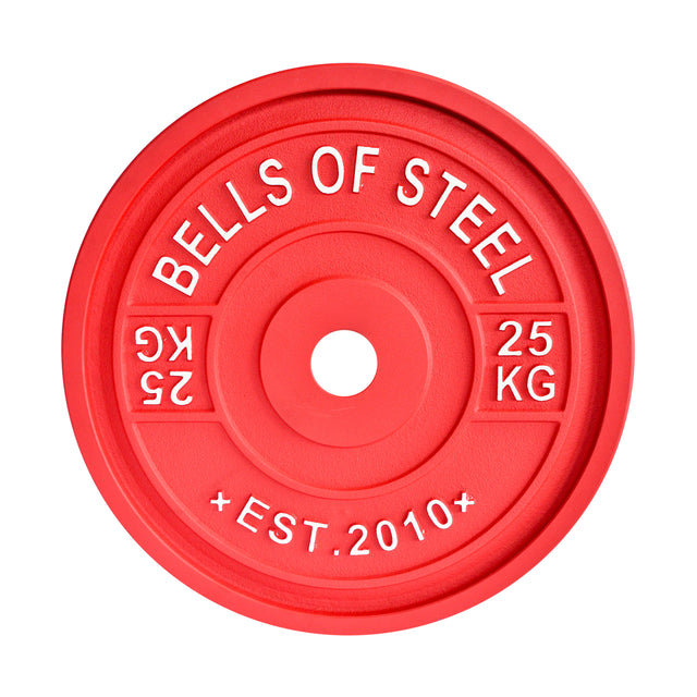 A red "Bells of Steel" calibrated powerlifting plate with "25 KG" and "EST. 2010" embossed, meets IPF specs for precise lifting. The central hole ensures seamless barbell attachment.