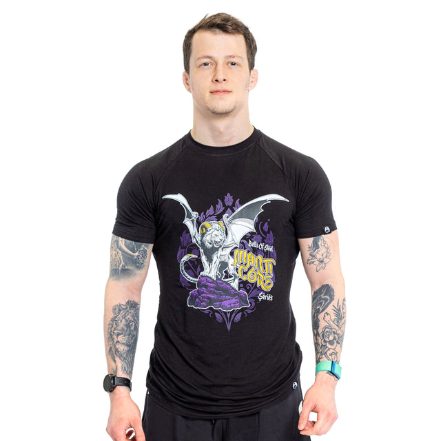 A tattooed man wears a black Bells of Steel Bamboo T-Shirt with a white winged gargoyle, purple accents, and "Dead End" and "Madtone" on the front, standing against a white background.