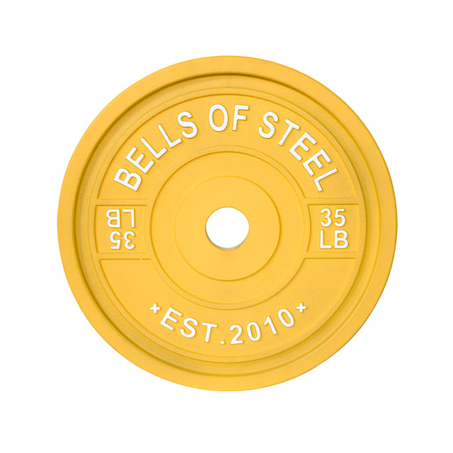 This yellow Calibrated Powerlifting Plate from Bells of Steel, founded in 2010, is ideal for training with "Bells of Steel" on top and mirrored "35 LB" on the sides. It fits easily on bars and adds vibrancy to any color-coded gym.