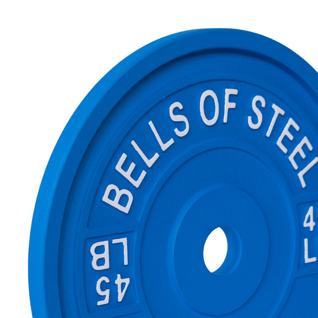 Close-up of a blue 45-pound Calibrated Powerlifting Plate from Bells of Steel, featuring "BELLS OF STEEL" in white. This color-coded plate has a smooth surface and central hole, ideal for precise lifting sessions.