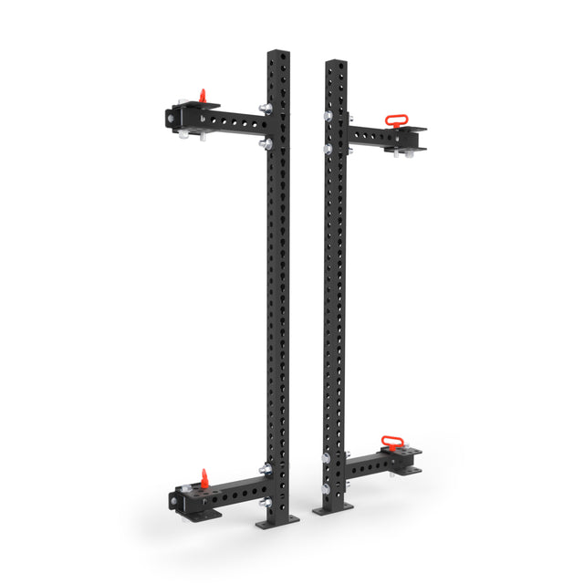 Two black metal Manticore Folding Half Rack - Prebuilt uprights (3" x 3", 1" holes) by Bells of Steel, with flat bases and red adjustment pins, designed as modular gym equipment for versatile fitness setups.