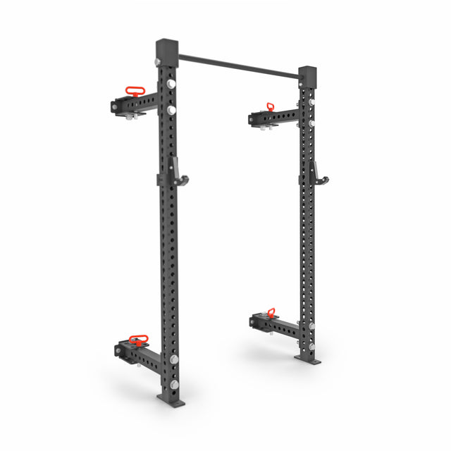 The Bells of Steel Manticore Folding Half Rack Builder is a black, adjustable squat rack ideal for small home gyms. It includes a pull-up bar, modular 3" x 3" components with 1" holes for height adjustments, safety hooks with red grips, and features a sturdy, minimalist freestanding design.