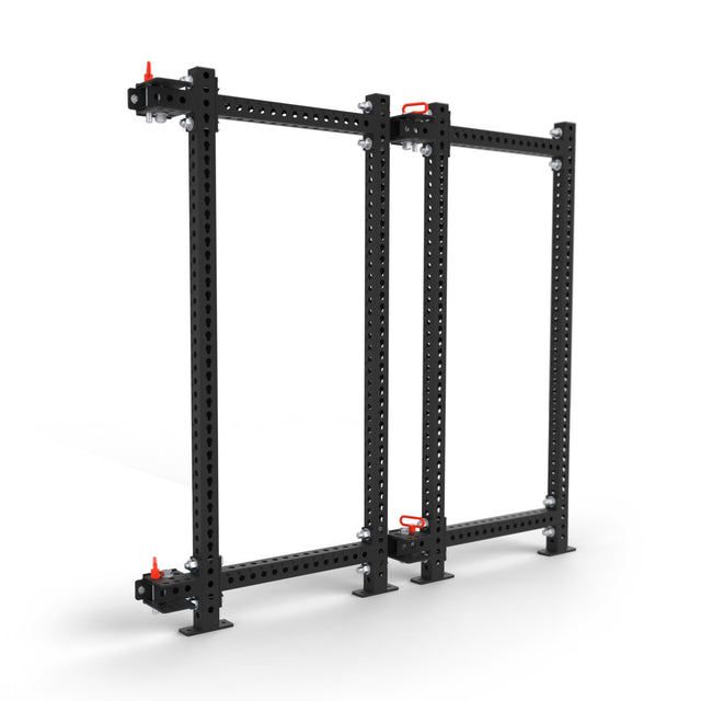 The Bells of Steel Manticore Folding Power Rack - Prebuilt (3" x 3", 1" Holes) stands upright on a white background, featuring black metal construction, red locking pins, and modular adjustable holes suitable for home gyms or industrial use.