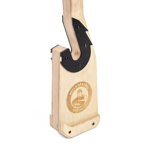 A close-up of the Bells of Steel Meat Hook Deadlift Jack, a portable wooden barbell jack with a black metal hook and engraved logo, designed for easily lifting barbells to add or remove weight plates.