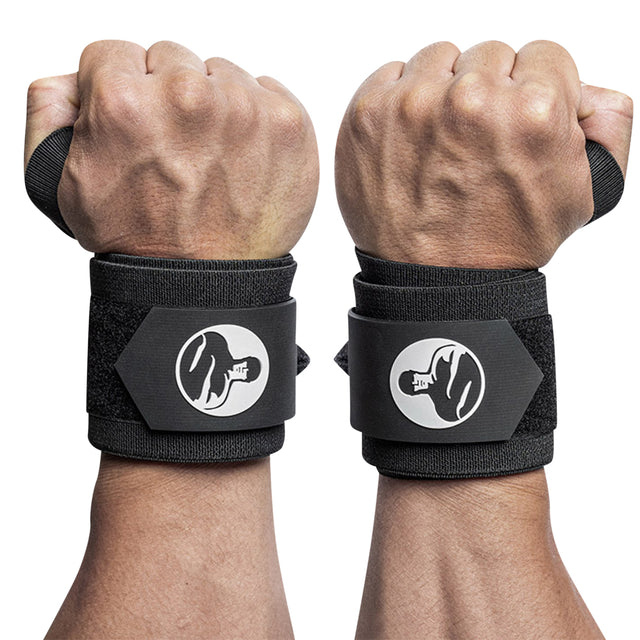 Two hands wearing Bells of Steel Mighty Wrist Wraps with thumb loops and white logos are clenched into fists, highlighting these powerlifting essentials designed for optimal wrist support during workouts.