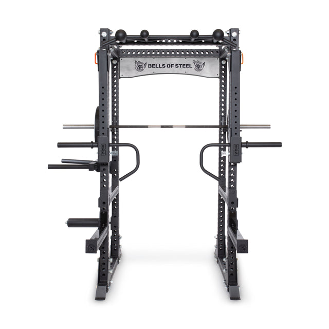 The Bells of Steel Manticore Flat Foot Power Rack Builder (3"x3", 1" holes) is a black steel rack with pull-up bars, dip handles, and a barbell holder; "BELLS OF STEEL" features on the top banner—ideal for versatile home gyms.