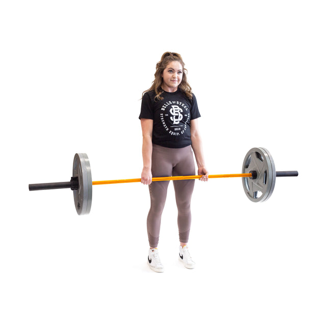 Dressed in a black t-shirt and brown leggings, a person performs a deadlift with the yellow Cerakote-coated Multi-Purpose Olympic Barbell – The Utility Bar by Bells of Steel, complete with two large weights. A crisp white background highlights their strength and focus.