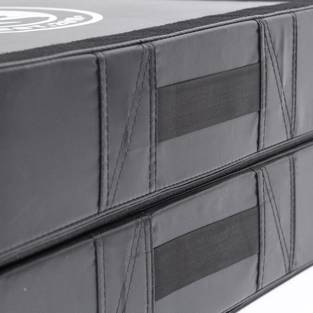 Close-up of two stacked Bells of Steel Deadlift Pads (Pair) in black, featuring reinforced stitching and side velcro strips for secure attachment and noise reduction during weightlifting.