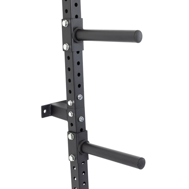 Close-up of the Bells of Steel Wall-Mounted Plate Storage Rack in black metal, featuring two horizontal pegs on a vertical, multi-holed frame—perfect for efficient home gym plate organization.