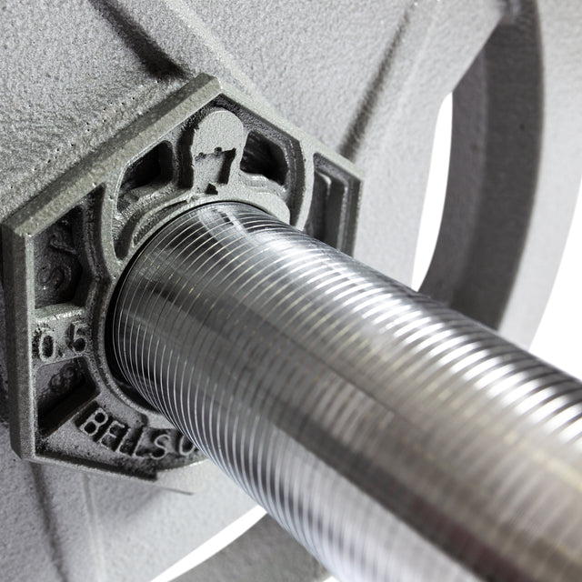 Close-up of the 38-inch Pro-Style Lat Bar Cable Attachment by Bells of Steel. The chrome, grooved bar features rubberized grips and is inserted through a weight plate, with the brand name and numbers partially visible on the plate.