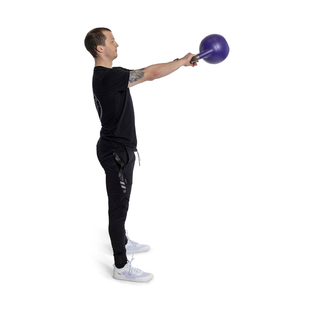 A person expertly performs a kettlebell swing with feet shoulder-width apart, holding a purple Bells of Steel Adjustable Competition Kettlebell in both hands. They're dressed in a black outfit and white shoes against a pristine white background.