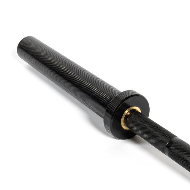 Close-up of a Bells of Steel black Short Rackable Barbell for your home gym, featuring a knurled sleeve with smooth rotation, textured grip, grooves, and a metallic ring near the grip transition.