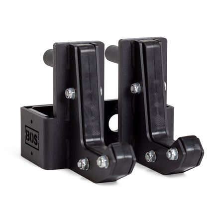 Two black metal Sandwich J-Cups by Bells of Steel with bolts and a rectangular base, designed as heavy-duty squat rack attachments. The BOS logo appears on the side of one holder.