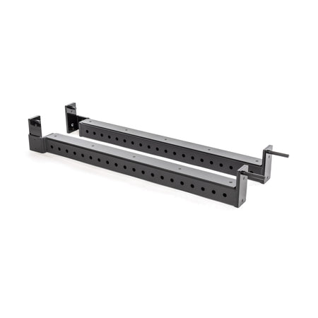 The Bells of Steel Flip-Down Safeties are black metal adjustable brackets with multiple holes, angled ends, and side arms for secure attachment to power racks—ideal for safely supporting heavy equipment during training.