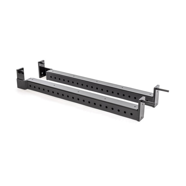 The Bells of Steel Flip-Down Safeties are black metal adjustable brackets with multiple holes, angled ends, and side arms for secure attachment to power racks—ideal for safely supporting heavy equipment during training.
