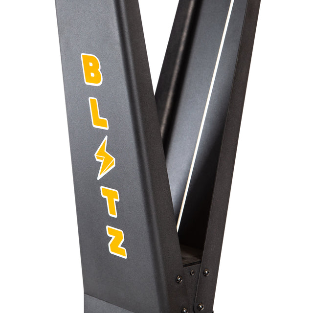 A close-up of the Blitz Ski Trainer by Bells of Steel, a black metal structure with "BLITZ" in bold yellow letters—lightning bolt for the “I”—inspired by ski trainer equipment for intense full-body workouts.