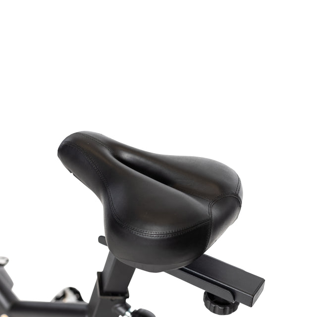 Close-up of a black cushioned ergonomic bicycle seat on a metal post against a white background. Ideal for the Bells of Steel Blitz Indoor Cycling Bike, it pairs with adjustable handlebars and magnetic resistance for an enhanced ride.