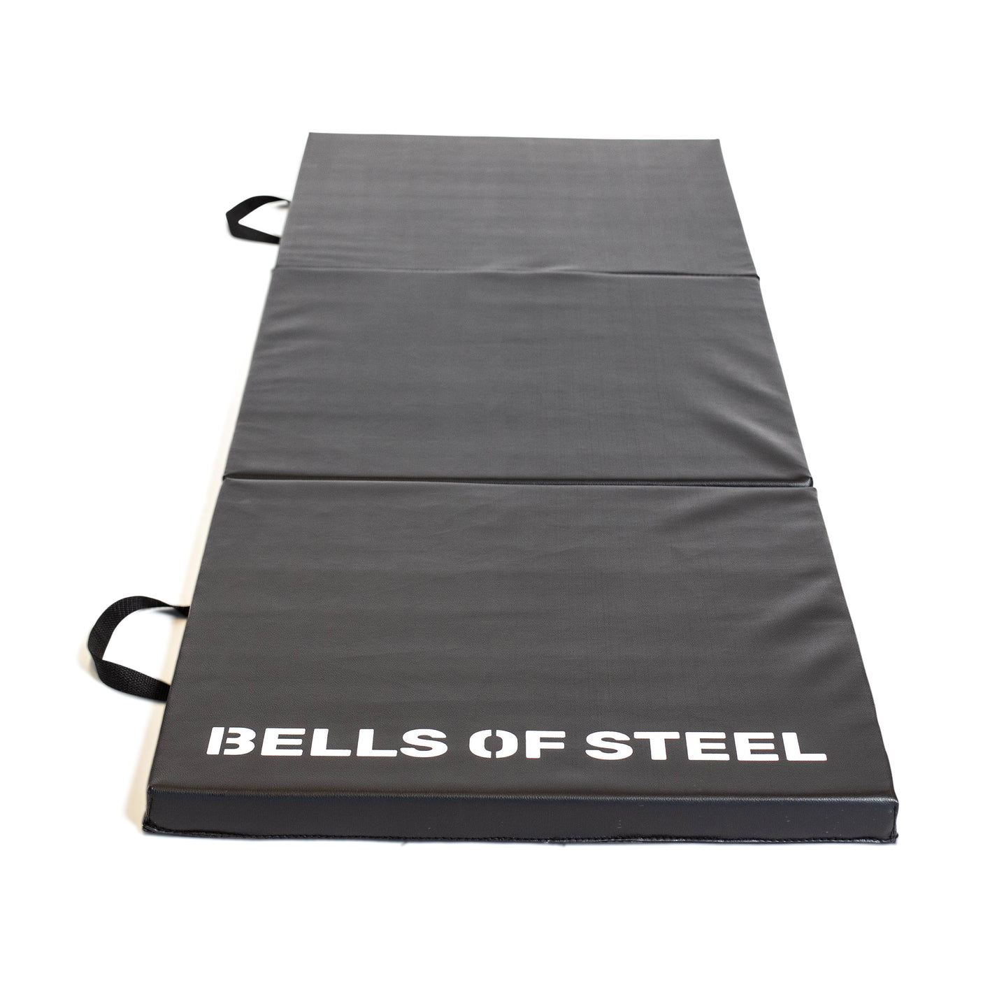 The Bells of Steel Trifold Mat is a black, non-slip workout mat with two side handles and "BELLS OF STEEL" printed in white at one end, shown laid flat on a white background.