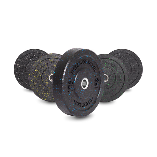 Bells of Steel's Crumb Bumper Plate Sets are crafted from crumb material with black, green, and yellow speckles. They have a central metal hub for bar use and weights labeled in kilograms for easy identification.