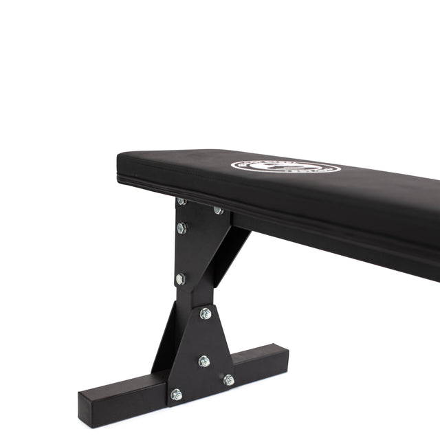 The Bells of Steel Flat Utility Bench, shown in black with a padded top and sturdy metal base, holds up to 661lb. Features visible bolts and a branded logo on the cushion—an affordable choice for your home gym.