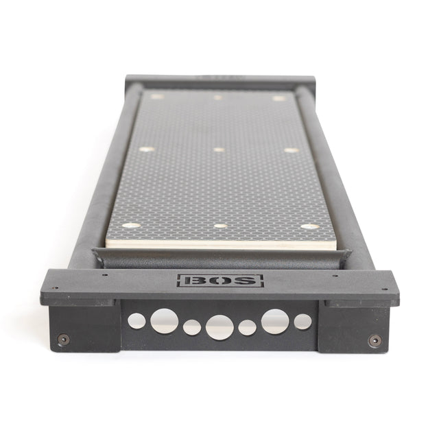 A Bells of Steel Utility Seat for Hydra/Manticore with a textured surface and black frame, shown from the end with logo and circular cutouts—ideal next to your adjustable bench or 3"x3" rack for versatile training setups.