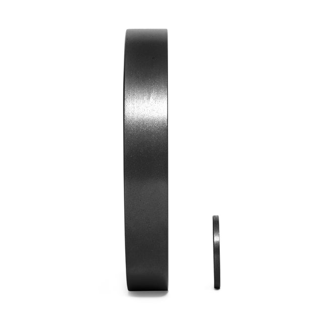 On a white background, two black circular magnets resemble the precision grip handles of Bell of Steel's Black Mighty Grip Olympic Weight Plates, with the larger magnet standing vertically and the smaller one sitting beside it.