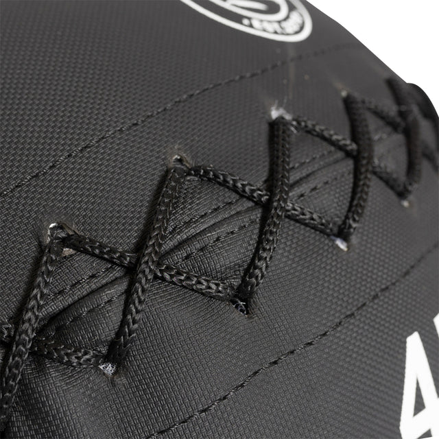 Close-up of black lacing on a textured baseball glove, highlighting detailed stitching. Durable Kevlar enhances longevity. Partly visible white logo at top corner.