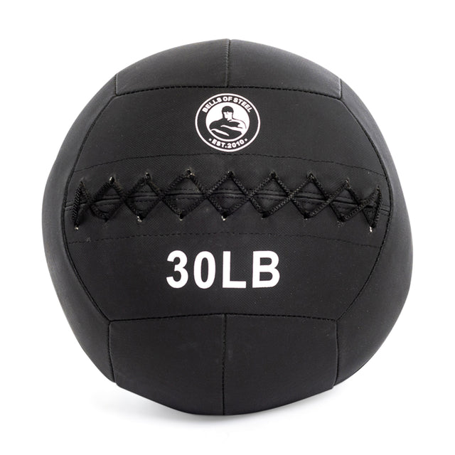 The "Triple Stitched Medicine Balls" by Bells of Steel feature a robust black design, ideal for all fitness levels. With "30 LB" displayed alongside a muscular arm logo, these balls boast durable Kevlar stitching through the center for guaranteed endurance and quality.