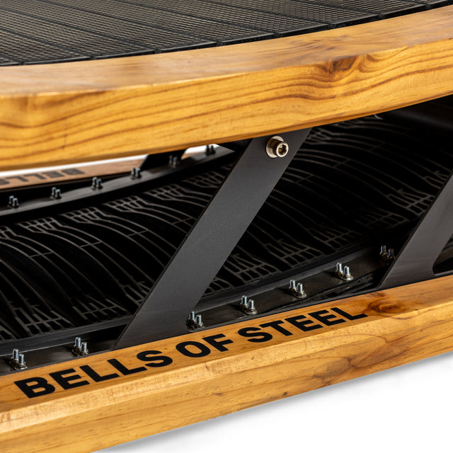 Close-up of the Wooden Residential Manual Treadmill by Bells of Steel, showcasing its compact, self-powered design. The frame artfully blends natural wood grain with sleek black metal for a perfect mix of function and style.