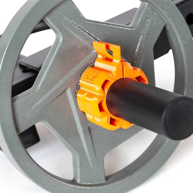 Close-up of a gray weight plate on a black barbell secured by an orange Barbell Zip Clip from Bells of Steel. The background is white.