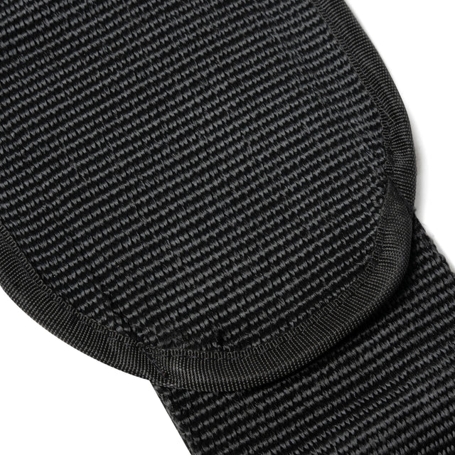 Close-up of a textured black fabric with curved, reinforced edges and detailed stitching from the Dip Belt by Bells of Steel USA, highlighting its durable and thick material designed for bodyweight training support.