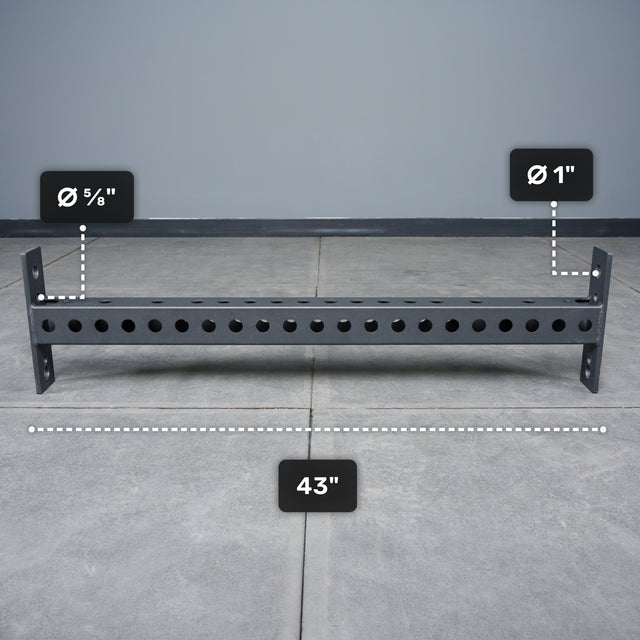 The Bells of Steel USA Crossmember For Converter Bench - 43" is displayed on a tiled floor, featuring evenly spaced holes with diameters of 5/8 inch and 1 inch along its 43-inch length.