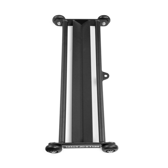 A black metal rack with two parallel bars and four corner wheels, shown from above on a white background. The "Bells of Steel" label is visible. Perfect for storing your Bells of Steel Glute Ham Slider after workouts.
