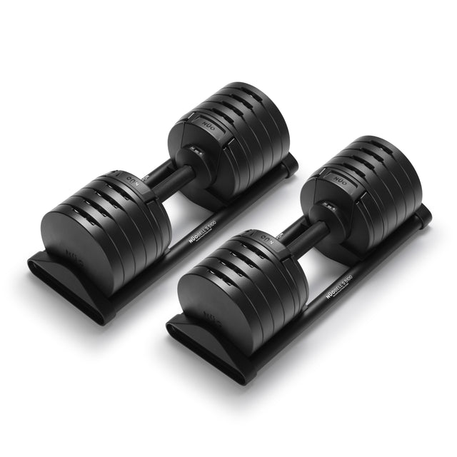 A pair of Bells of Steel USA NÜOBELL-S Adjustable Dumbbells with black plates on their stands, showcased against a white background—ideal for any home gym setup.