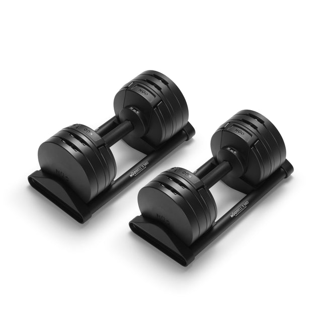 A pair of Bells of Steel USA NÜOBELL-S Adjustable Dumbbells with weight markings rest on matching black stands against a white background—ideal for any home gym.