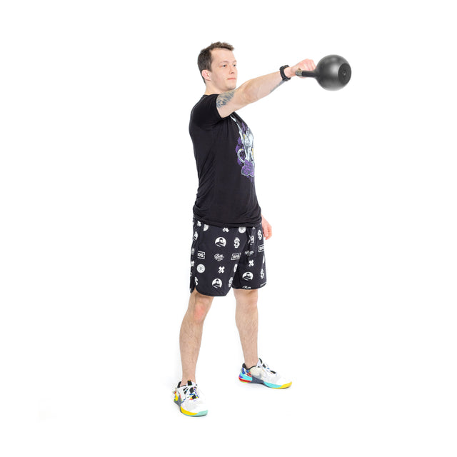 A man in a black tee, printed shorts, and colorful sneakers performs a front raise with the Bells of Steel 6-12KG Adjustable Kettlebell, holding it straight out in front of him with one arm. White background.