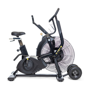 A black air bike exercise machine with pedals, handlebars, a fan wheel at the front, and a small display screen. It has an adjustable seat and is set on a white background.