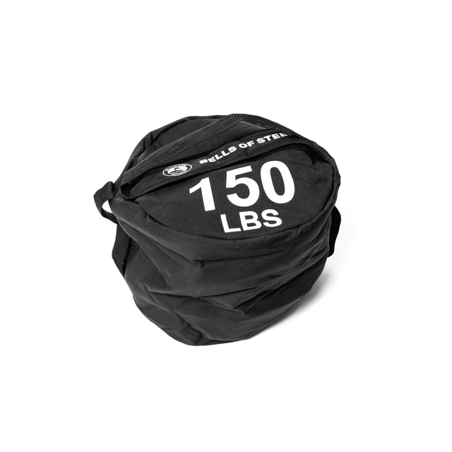 A Bells of Steel Fitness Sandbag in black, featuring a carrying handle and bold white text reading "BELLS OF STEEL" and "150 LBS," is crafted from durable Cordura construction and folded neatly against a plain white background.