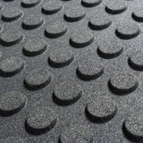 Close-up of Bells of Steel Rubber Flooring Gym Mat 24" x 24" shows its textured black surface with evenly spaced, raised circular bumps for enhanced grip and safety—ideal for heavy-duty gym environments.