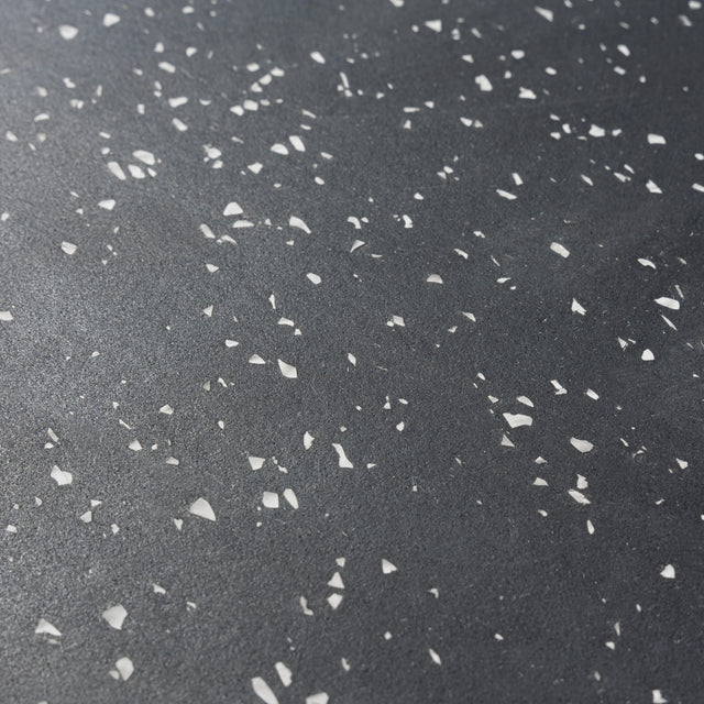 Close-up of the Bells of Steel Rubber Flooring Gym Mat 24" x 24" in dark gray with white stone chips, featuring a speckled, textured surface ideal for durable, heavy-duty gym spaces.