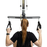 A person with long red hair in a ponytail prepares to exercise, gripping the Bells of Steel 30 D-Handle Bar Cable Attachment with Carabiners at a lat pulldown machine. The white background highlights their visible back and arms.