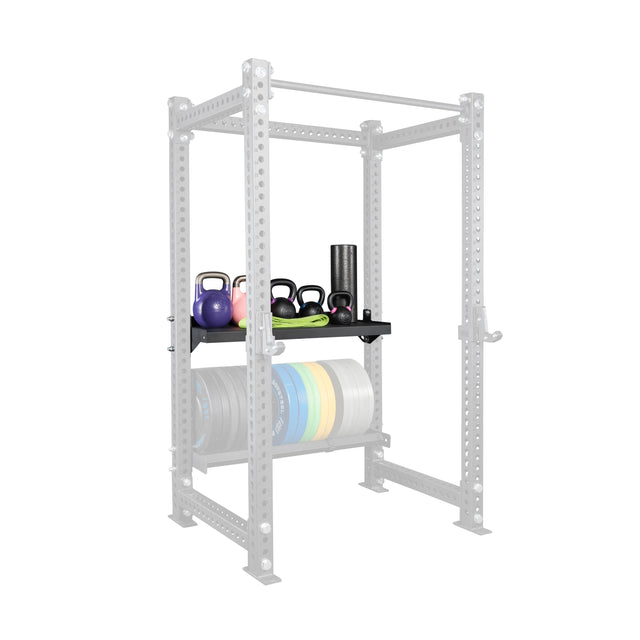 The Bells of Steel USA Storage Shelves keep kettlebells, a foam roller, and resistance bands organized on top, with weight plates stored below. The faint gray frame helps you tidy your gym gear beside your power rack.