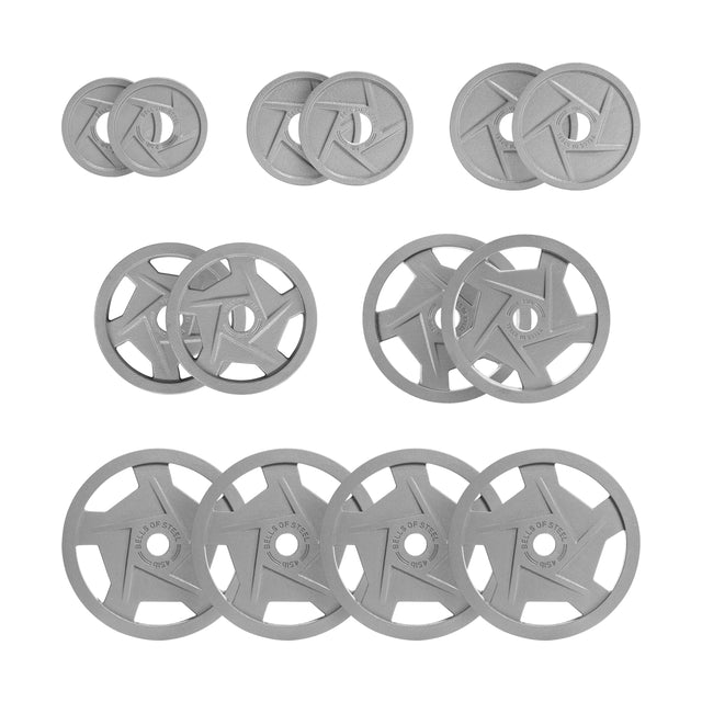 A set of Gray Mighty Grip Olympic weight plates by Bells of Steel is arranged in three rows: the top with four small plates, the middle with larger precision grip ones, and the bottom displaying the largest plates engraved with "4 KG" and "VULCAN STRENGTH.