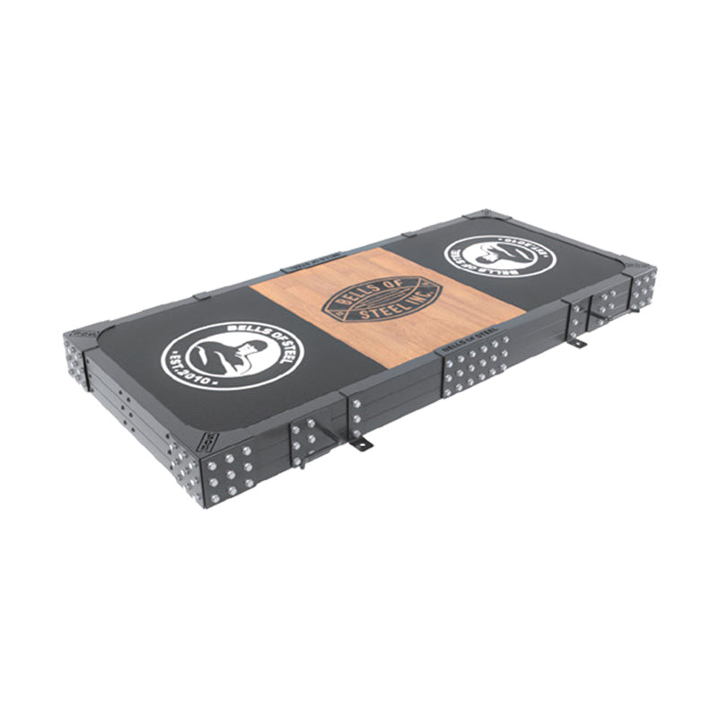 The Bells of Steel Weightlifting Platform features a rectangular black and brown steel frame with "RINGS OF STEEL" and a gorilla face logo on each end and center—ideal for home gyms, weightlifting platforms, or deadlift pads.