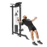 Wearing a black t-shirt, black shorts, and sports shoes, a bearded man with glasses uses the Bells of Steel's Kraken Rack Attachment for 4 Post Hydra & Manticore Racks (Single Side) during his workout. He grips the cables attached to this system, featuring adjustable weights and sturdy trolleys.