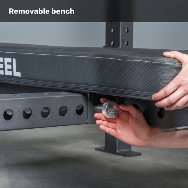 A person secures or removes the padded bench from a metal rack, showcasing the floating bench design of the Bells of Steel USA Hydra Four Post Converter Bench. "Removable bench" appears top left.