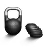 The Bells of Steel Mark Wildman Adjustable Kettlebell in black, featuring a metallic handle and co-designed with Mark Wildman, stands upright beside five round weight plates stacked on their sides, all set against a white background.