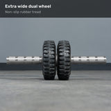 The ABsyidyan Stainless Steel Ab Roller by Bells of Steel USA, featuring extra-wide dual wheels and a 500 lb capacity, stands upright on a gray floor. Text above reads: "Extra wide dual wheel. Non-slip rubber tread.