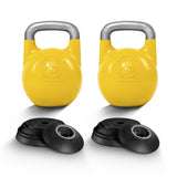 Two yellow Bells of Steel Adjustable Competition Kettlebells with gray handles stand upright, each displaying the brand logo. Several black weight plates are stacked in front of each kettlebell, all set against a white background.